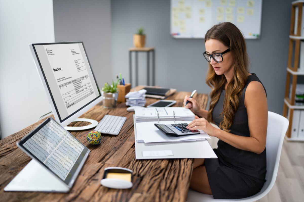 Image d'une femme dans un bureau, concentrée devant son ordinateur, symbolisant des solutions pratiques pour simplifier la comptabilité d’une SCI familiale.