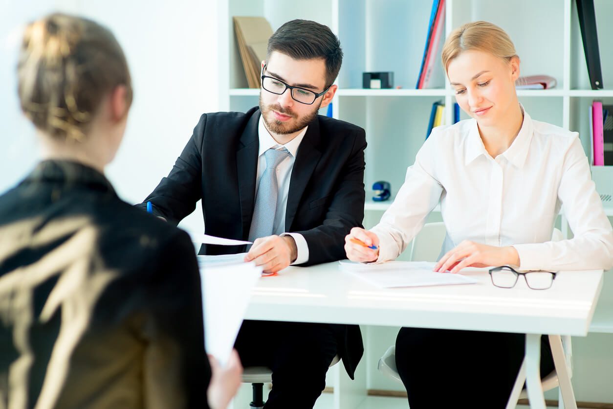 Image de deux personnes dans un bureau, examinant des documents financiers et discutant des étapes essentielles pour financer l'achat de parts SCPI avec un crédit. Des graphiques et des calculs sont visibles, illustrant le processus de financement.