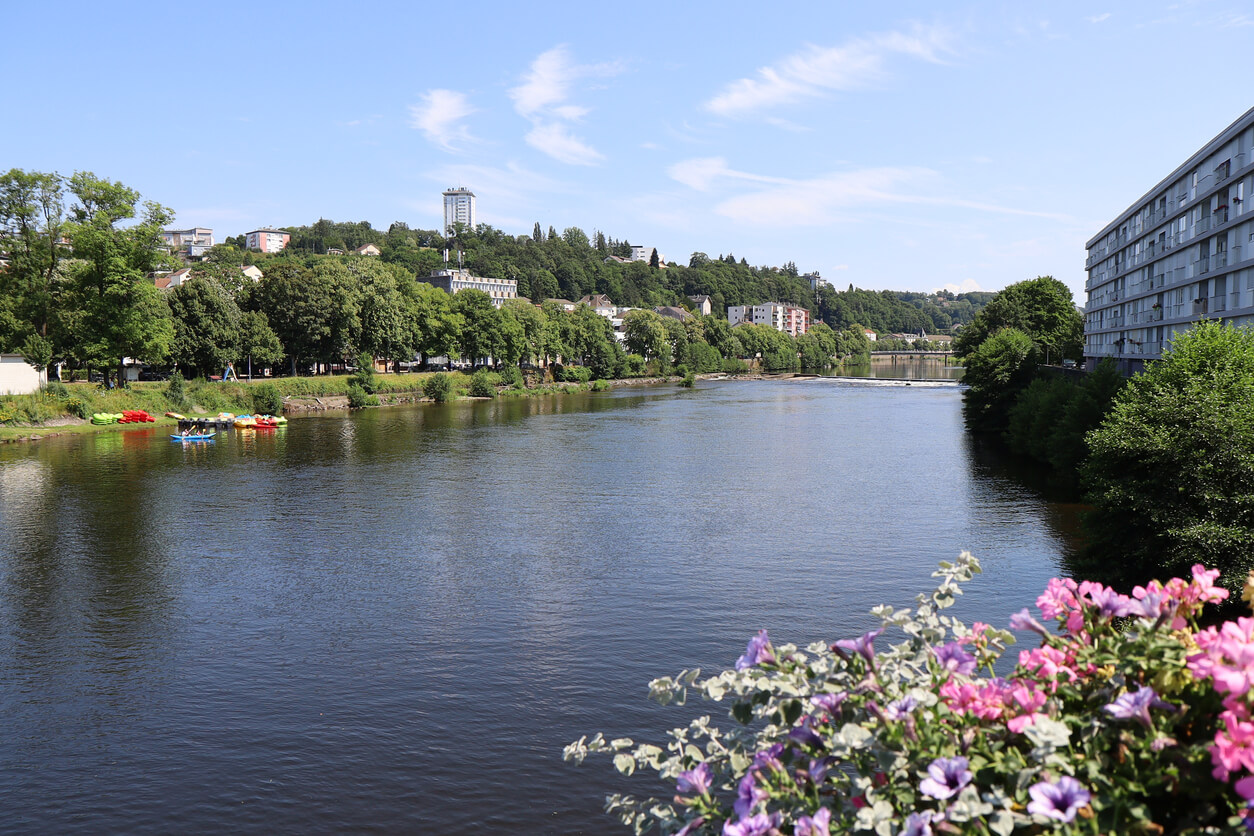 Vue de la rivière Moselle traversant la ville d'Épinal, entourée de verdure et d'immeubles résidentiels, idéale pour un investissement locatif Épinal