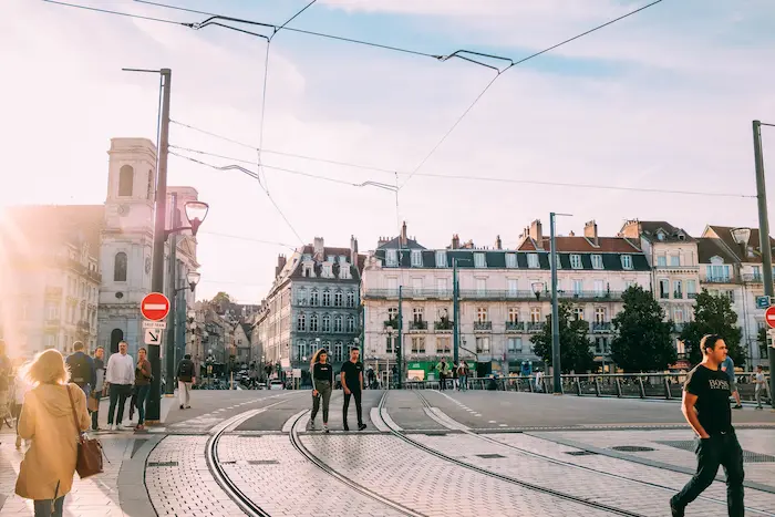 Rue européenne avec rails de tram, immeubles historiques et ambiance chaleureuse illustrant un cadre urbain propice à investir dans l’immobilier.