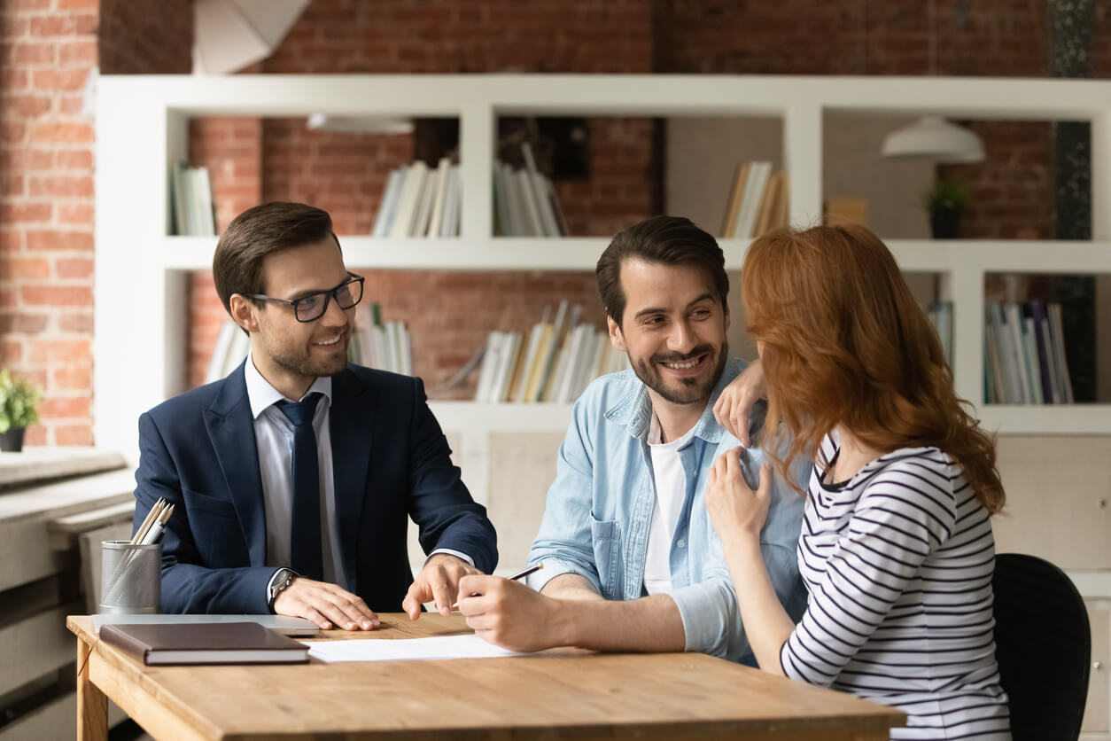 Trois personnes discutant de la pertinence d'une SCI pour l'investissement locatif, analysant ses avantages fiscaux et juridiques