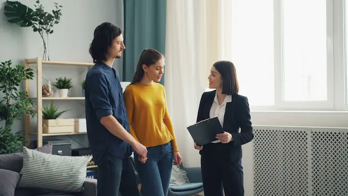 Consultant tenant un dossier face à deux clients, image claire d’une rencontre autour d’un crédit immobilier locatif.
