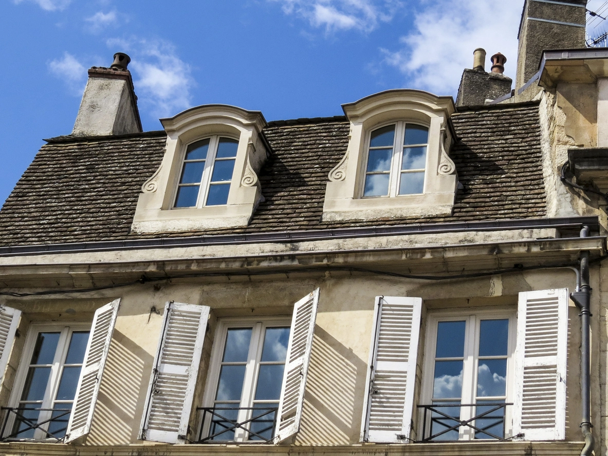 Toiture en tuiles et fenêtres typiques d'une maison ancienne en France, un choix à considérer lorsqu'on souhaite Acheter neuf ou ancien en immobilier