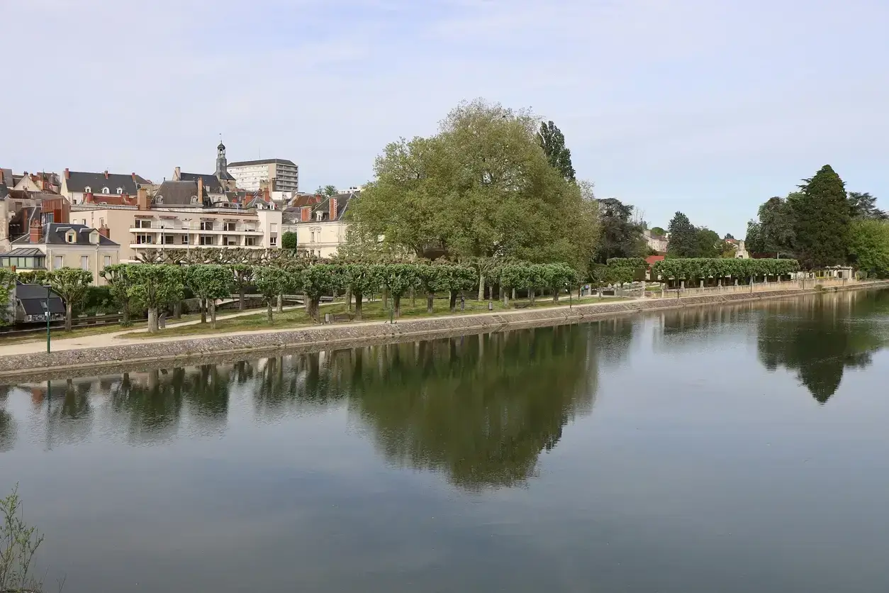 Vue paisible de Vierzon avec rivière reflétant arbres et bâtiments