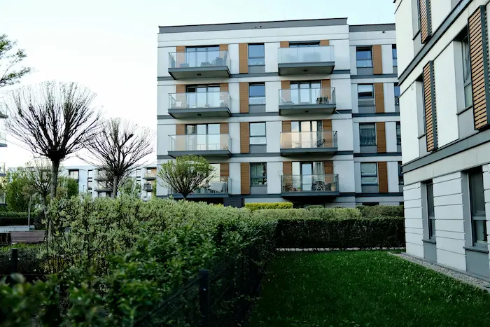 Résidence moderne aux lignes épurées avec balcons vitrés et espaces verts, idéale pour un achat d’appartement neuf 