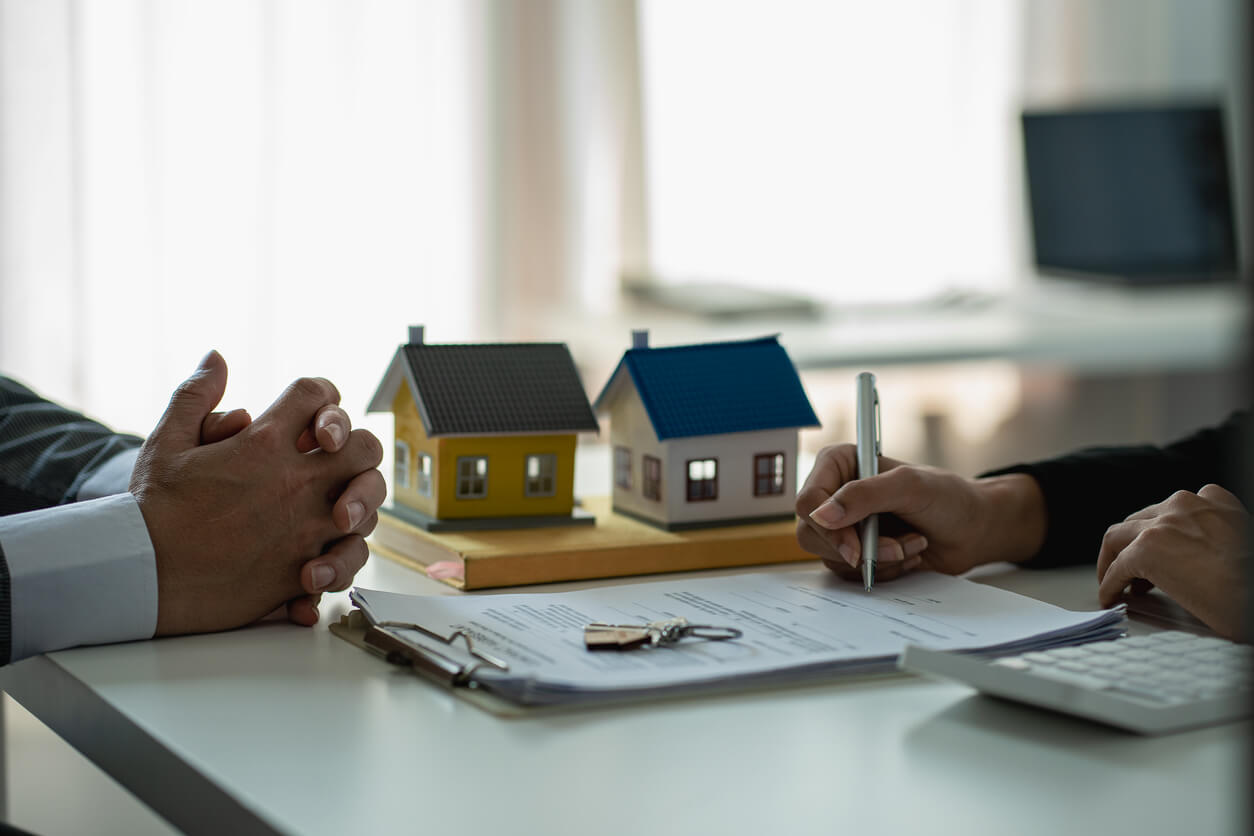 Deux personnes évaluant la valeur d’un bien immobilier pour un apport dans une SCI, étape essentielle pour déterminer la contribution au capital social.