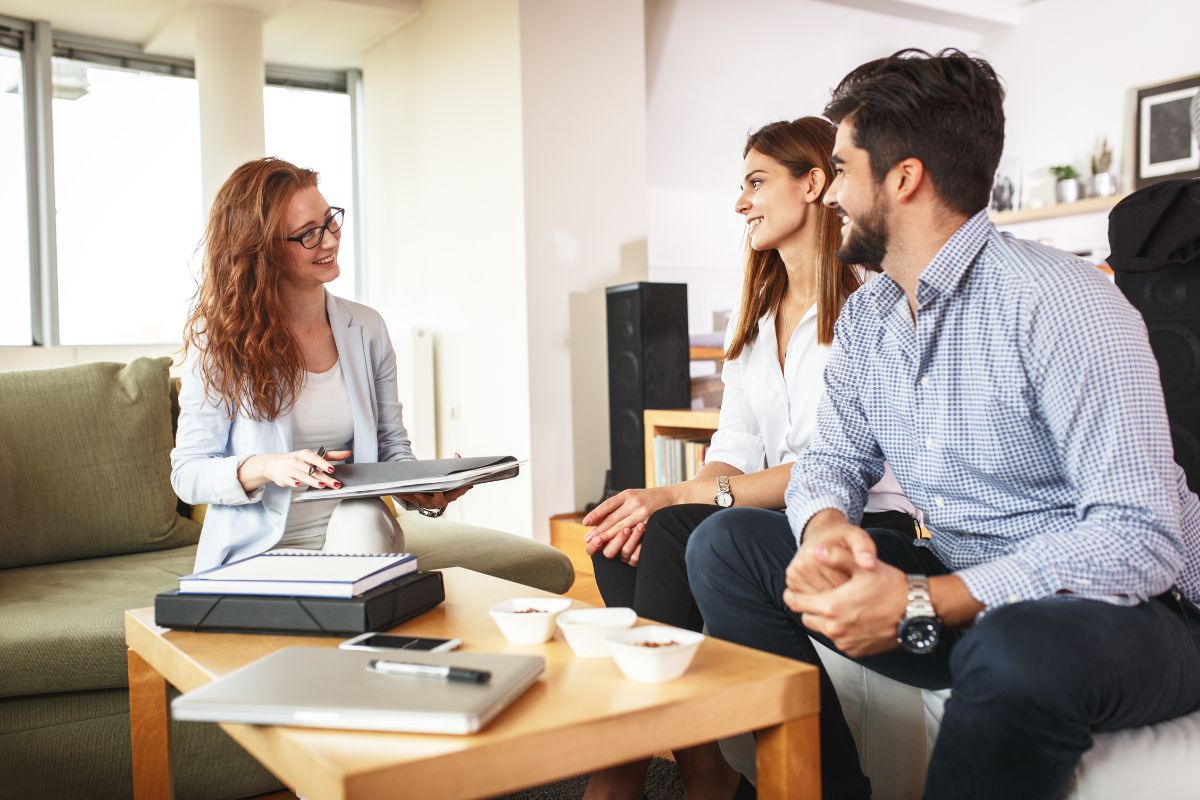 Image d'un couple en consultation avec un expert SCI, discutant des avantages patrimoniaux de la création d'une SCI pour la gestion et la transmission du patrimoine immobilier.