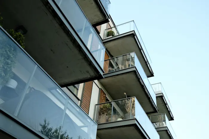 Immeuble moderne avec balcons vitrés et façade boisée, parfait pour l’immobilier locatif urbain offrant confort et rentabilité aux investisseurs.