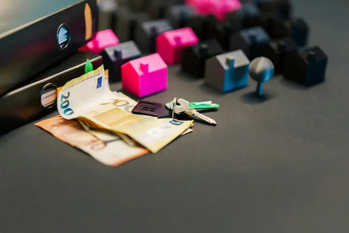 Clés posées sur billets d’euros avec maison miniature, image illustrant le plafond PEL et la gestion de l’épargne immobilière.