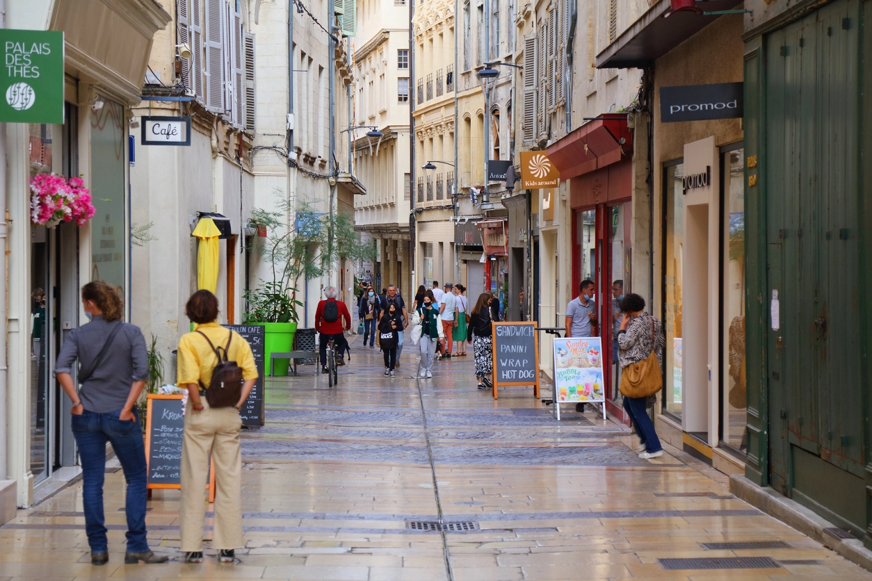 Des touristes arpentent les ruelles animées du centre d'Avignon. L'image montre un environnement parfait pour un investissement locatif Avignon, grâce à son dynamisme attractif