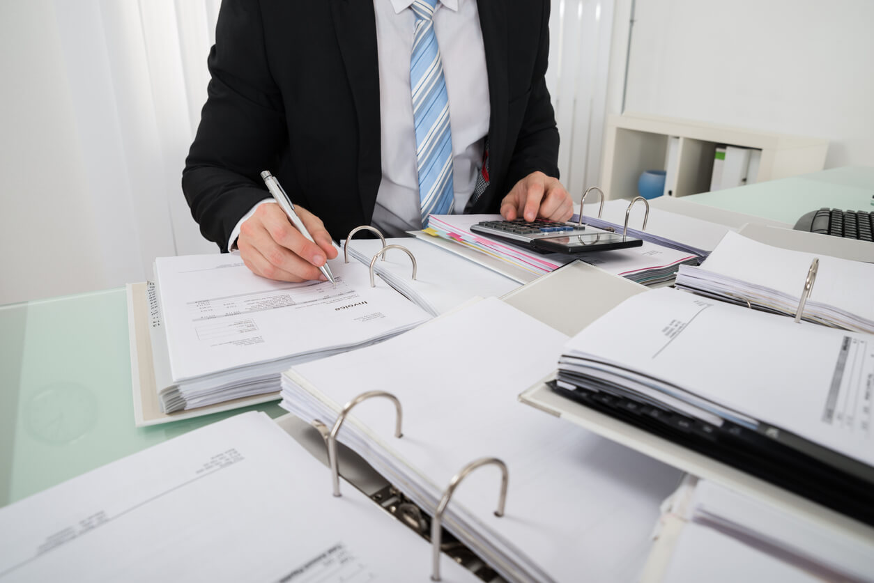 Des formulaires et dossiers administratifs soigneusement organisés sur un bureau, symbolisant les démarches nécessaires pour acheter en SCI familiale et sécuriser un investissement immobilier collectif.