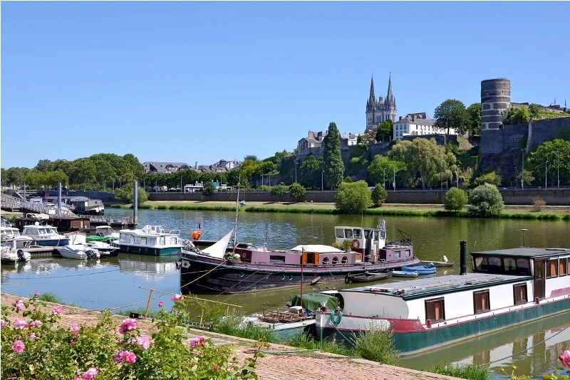 Vue sur Angers et son cadre pittoresque, avec image de fond un lac et des bateaux, l'une des raisons de trouver une location appartement Angers