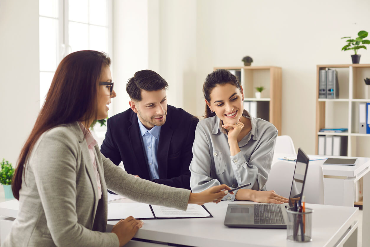 Image d'un couple en discussion avec un expert immobilier : comprendre les coûts et démarches pour l'achat d'une résidence principale en SCI, incluant les frais de notaire et les avantages fiscaux.