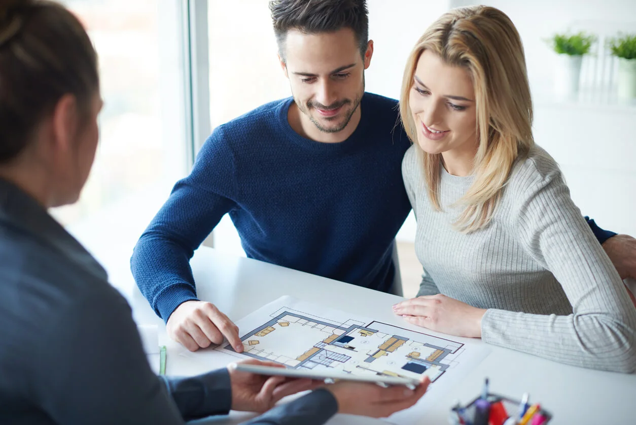 Un couple examine des plans immobiliers dans un cadre lumineux, symbolisant la concrétisation d’un projet immobilier. Grâce au taux PEL garanti à 1,75 % en 2025, ils envisagent de financer leur futur logement avec sérénité et sécurité financière.