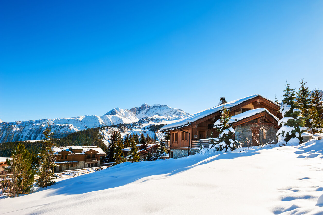 Maison au milieu de la neige sous un ciel bleu éclatant pour un LMNP tourisme