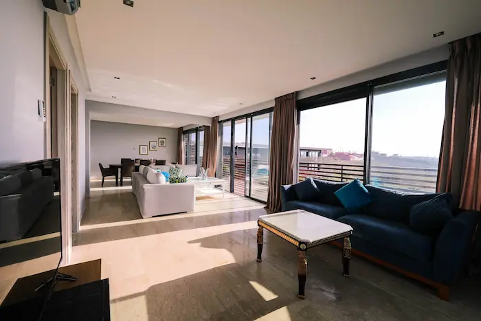 Pièce élégante avec sols en marbre et mobilier design, image claire d’un appartement meublé contemporain.