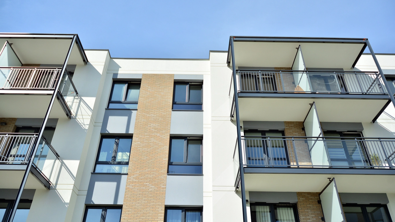 Façade d'un immeuble moderne avec balcons, illustrant le choix d'acheter neuf ou ancien selon les préférences et besoins en immobilier