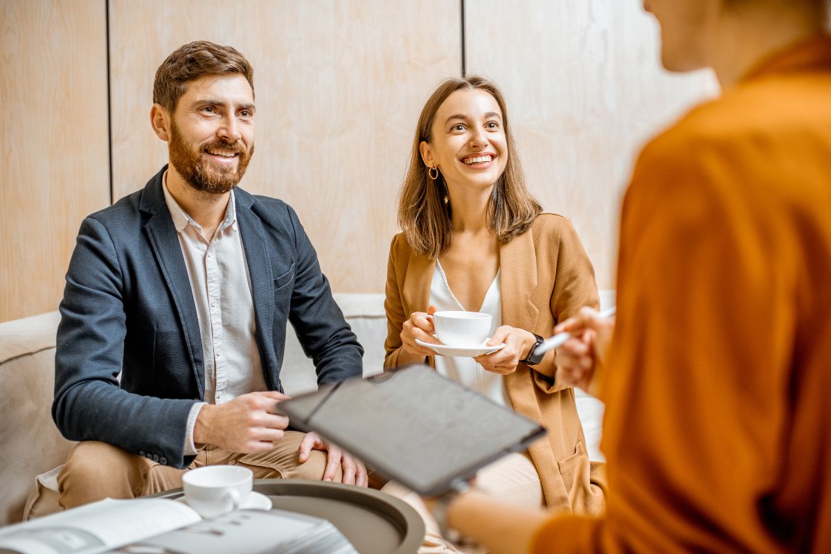 Un couple échange avec une experte en SCI sur les stratégies pour optimiser les plus-values immobilières.