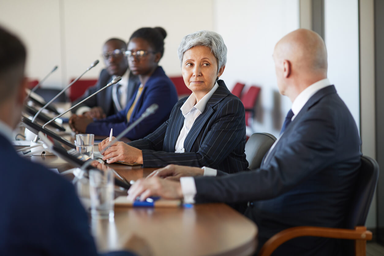 Un groupe de professionnels en réunion d'affaires discute de la gestion en Société Civile Immobilière personne morale ou physique.