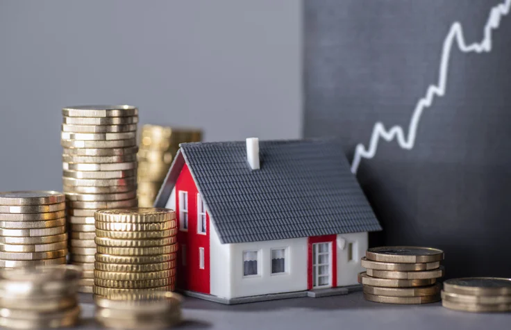 A model of a house surrounded by stacked money, and an arrow going up, symbolizing the profitability of an apartment in rental management